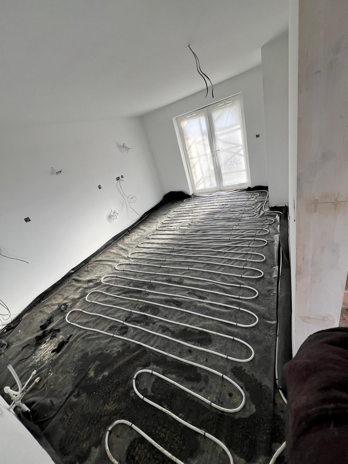 Underfloor heating loops laid in a new-build room